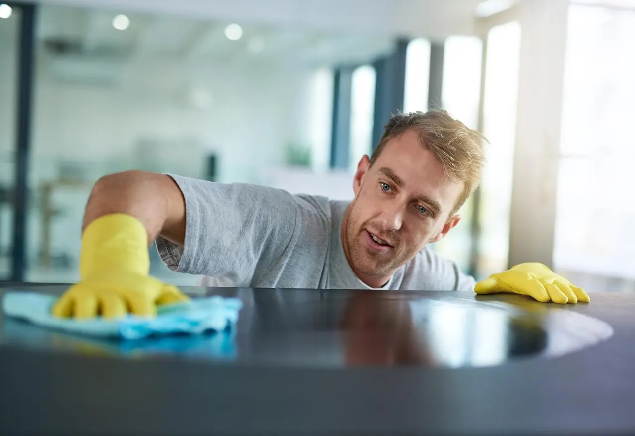 Büroreinigung Pforzheim – Reinigungskraft wischt eine Schreibtischfläche