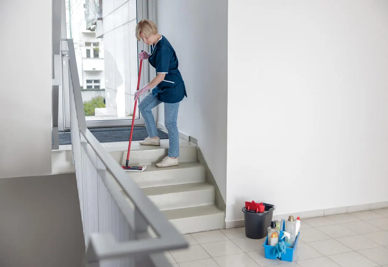 Treppenhausreinigung Pforzheim – Reinigungskraft wischt mit Mopp die Stufen